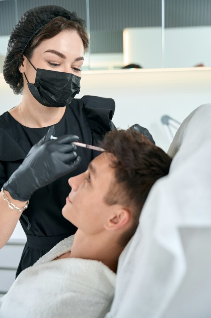 Male in beauty clinic getting hair injection procedures
